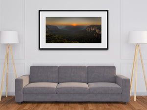 A panoramic Govetts Leap photograph captures sunrise over dark green forest