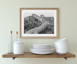 A black and white photograph follows the Great Wall across scrub-covered winter hills
