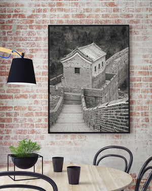 A vertical monochrome photograph captures steep stairs and historic Chinese fortifications