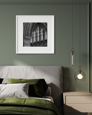 Repeating arched windows rise between dark columns in a Dutch church interior