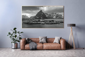 Schwere Wolken erstrecken sich über einem Lofoten-Dorf und seiner Bergkulisse
