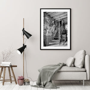 Monochrome Havana scene with a horse-bird mural, staircase and television beneath a timber ceiling.