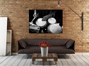 Monochrome performance photograph of a Havana percussionist playing drums and metal percussion instruments.