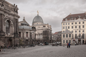 صورة معمارية لساحة ألمانية بها مباني حجرية منحوتة ونوافذ مقوسة ومشاة.