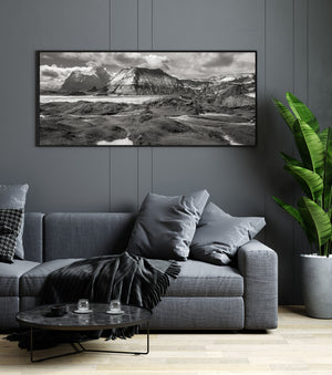 Reflektierende Teiche unterbrechen den dunklen Vulkanboden unter hoch aufragenden isländischen Bergkämmen.