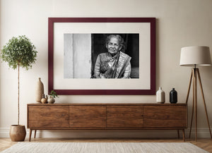Black and white portrait balancing an Indian woman’s face and saree with a pale doorway wall.