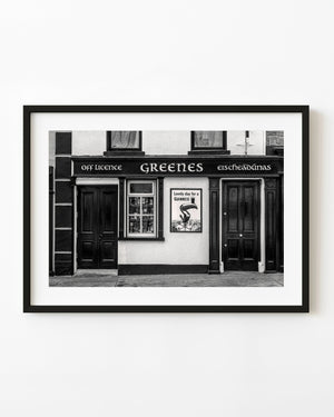 Black and white photograph of Greenes Irish pub frontage with dark wooden doors and a Guinness sign.