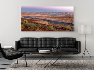 Panorama en color del paisaje de arenisca del lago Powell bajo un suave cielo rosado del amanecer.