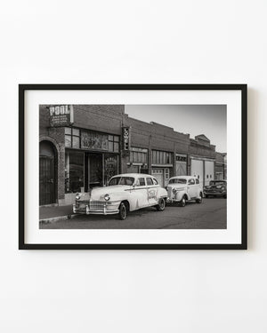 Vintage cars parked along historic Lowell Arizona street in black and white