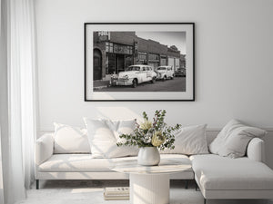 Paysage de rue monochrome avec des véhicules d'époque et des vitrines historiques