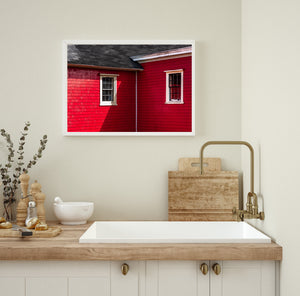 Colour photograph of sunlit red shingles and dark window panes in Lunenburg