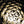Golden bottle shapes curve around the centre of a dark circular composition