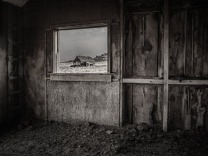 Old barn window framing farmhouse
