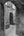 A broad stone arch frames a narrow doorway in a textured medieval wall