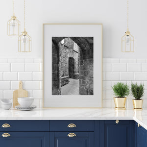 Light falls on rough stonework inside a Mont Saint-Michel passage