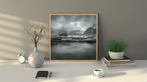 Storm clouds above a rugged Norwegian shoreline and mountains