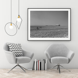 Weathered wooden barn beneath a broad pale sky in rural Nebraska