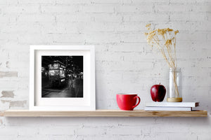 Schwarz-weißes Straßenfoto eines Imbisswagens unter den Lichtern der Stadt