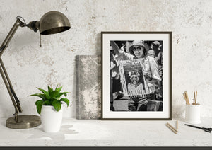 Candid New York parade portrait with a raised arm and illustrated sign