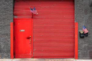 Porte industrielle rouge vif encastrée dans une maçonnerie sombre de New York