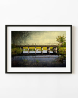Northern Ontario country bridge reflected in still wetland water