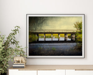 Bridge railings and supports mirrored in calm water