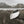 Weathered boat on brown grass below snow-streaked peaks