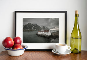 Dark water surrounding a weathered Norwegian seaside building