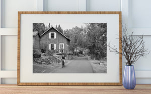 Jeune cycliste à côté d'une maison en bois et d'arbres feuillus en Ontario