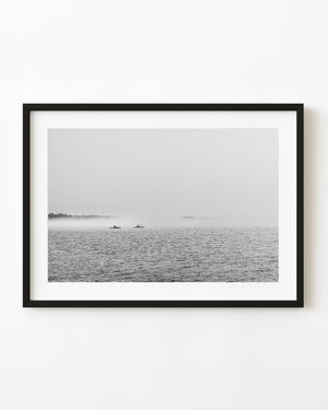 Two kayakers paddling through morning mist on Ontario water, black and white