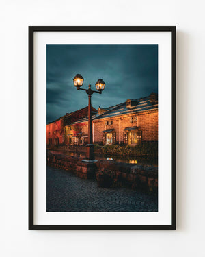 Otaru canal warehouses at night with glowing streetlamp