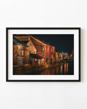 Historic red brick warehouses beside Otaru Canal at night