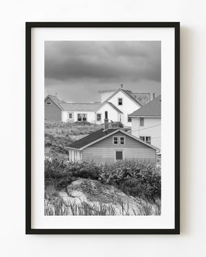 Dorfhäuser auf einem grasbewachsenen Felshang in Peggy’s Cove, schwarz und weiß