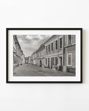 Quiet cobblestone street lined with old façades in Brasov Romania