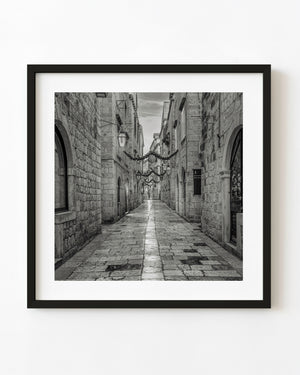 Quiet stone street in Dubrovnik Old Town with hanging lanterns and winter decorations