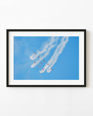Red Arrows-Flugzeuge in Formation unter sich kräuselndem weißem Rauch vor blauem Himmel