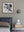 Square monochrome photograph of a densely furnished vintage kitchen