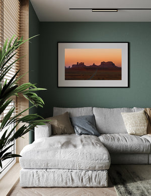 Panoramic desert landscape with a road beneath an orange sky