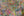 Overlapping turquoise pink yellow and black markings on a textured wall