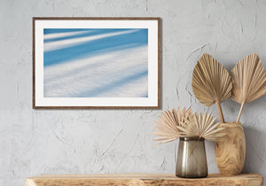 Glitzernder Schnee unter weiten blauen Baumschatten