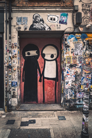 Red doorway painted with two cartoon figures beneath a pigeon mural