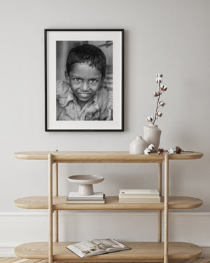 Black and white photograph of a smiling child looking at the camera
