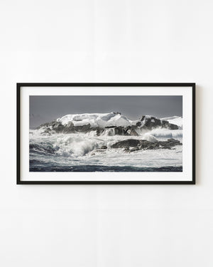Southern Ocean waves against snow-covered Antarctic rocks