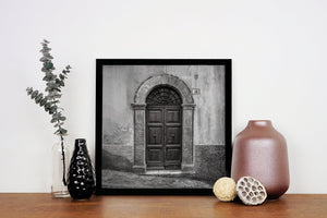 Quadratisches monochromes Foto einer alten italienischen Tür und einer strukturierten Wand.