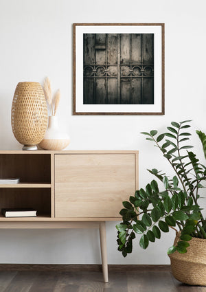 Fotografía arquitectónica apagada de paneles metálicos remachados y una manija de puerta antigua.