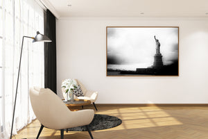 Statue of Liberty stands above dark stone walls beside the harbor.