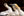 Close-up of three gannets with overlapping necks against a dark background.