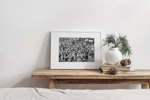 New York City crowds fill the frame beneath signs and illuminated shopfronts.