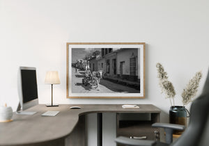 Monochrome Cuban street scene with a horse-drawn cart and traditional houses.