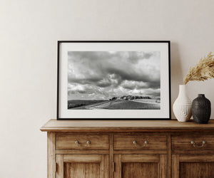 Monochrome Tuscan vineyard photograph with strong patterns in vines and clouds.